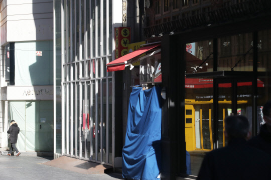 정부가 사회적 거리두기 3단계 격상을 검토 중인 17일 오후 서울 명동 일대의 상점들이 영업시간 단축과 폐점 등으로 닫혀 있다.   연합뉴스